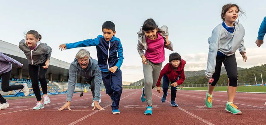 A group of kids and their PE teacher on the running track (photo)